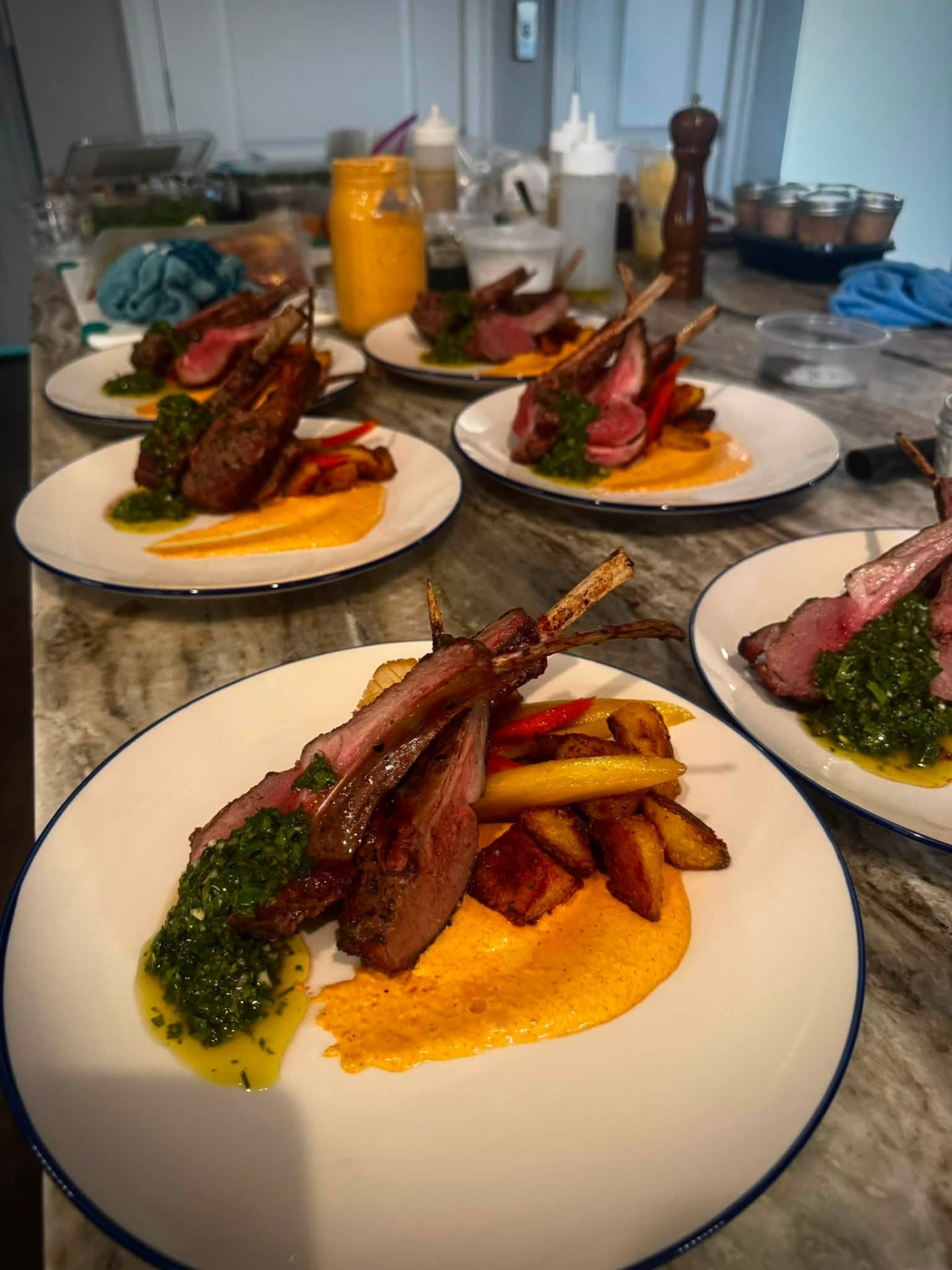 Plated lamb lollipops with harissa, chimichurri and crispy potatoes served at a private dinner party in Virginia Beach, VA