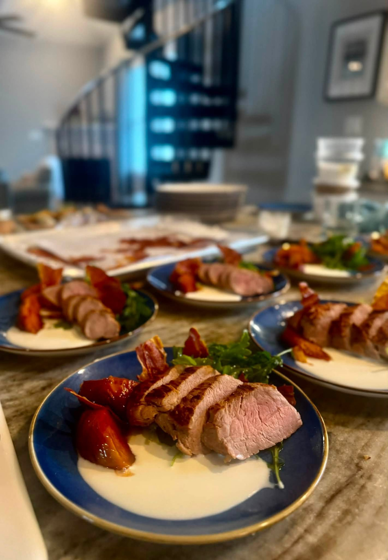 Plated pork tenderloin courses lined up on a marble counter at a private dinner in Virginia Beach, VA